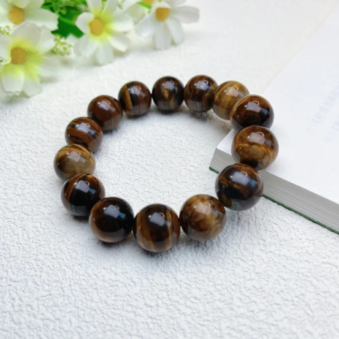 alt="tiger eye stone bracelet for men in hand"