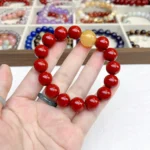 alt="big cinnabar bracelet and yellow carnelian on hand"