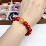 alt="big cinnabar bracelet and yellow carnelian on hand"