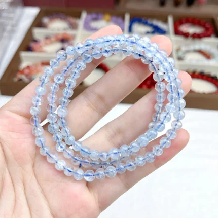 alt="blue crystal multi loop bracelet in hand"