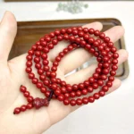 alt="cinnabar long bracelet in hand"