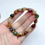 alt="colour jade bracelet in hand"