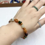 alt="colour jade bracelet on hand"