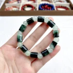 alt="cylinder shaped jade bracelet on hand"