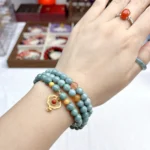 alt="multi loop deep green jade bracelet on hand"