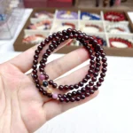 alt="multi loop pomegranate rose bracelet in hand"