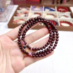 alt="multi loop pomegranate rose bracelet on hand"