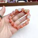 alt="orange crystal bracelet in hand"