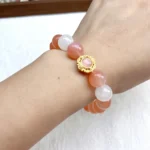 alt="orange crystal bracelet on hand"