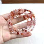 alt="orange multi loop crystal bracelet in hand"