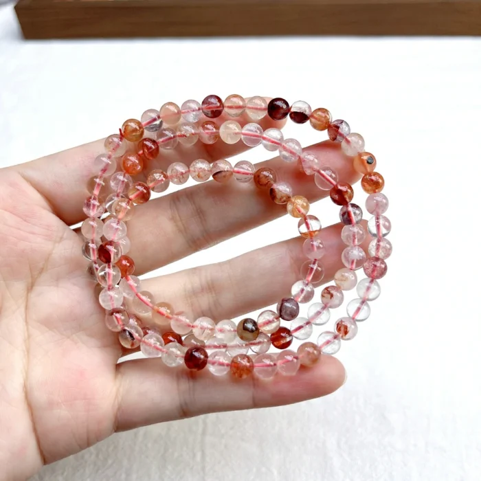 alt="orange multi loop crystal bracelet in hand"