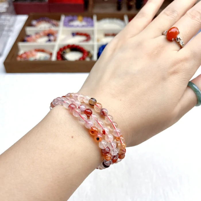 alt="orange multi loop crystal bracelet on hand"