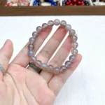 alt="pure grey crystal bracelet in hand"