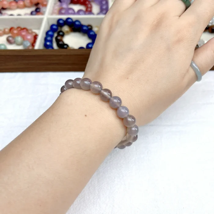 alt="pure grey crystal bracelet on hand"