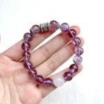 alt="pure purple crystal bracelet in hand"