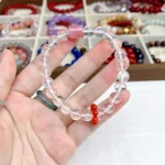 alt="pure white crystal bracelet in hand"