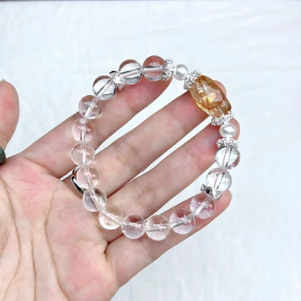 alt="pure white crystal bracelet in hand"