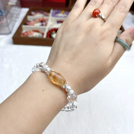 alt="pure white crystal bracelet in hand picture"