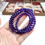 alt="purple multi loop crystal bracelet in hand"