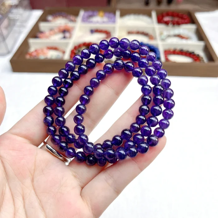 alt="purple multi loop crystal bracelet in hand"