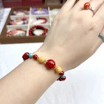 alt="red cennabar bracelet on hand"