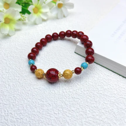 alt="red cinnabar bracelet on hand picture"