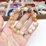 alt="yellow crystal bracelet in hand"