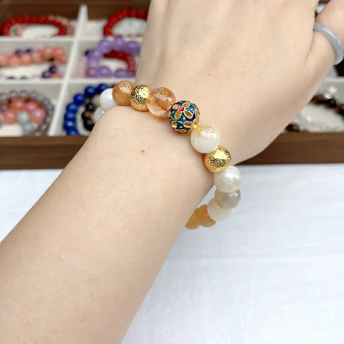 alt="yellow crystal bracelet on hand face"