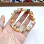 alt="yellow crystal bracelet on hand photo"