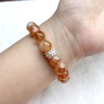 alt="yellow crystal bracelet on hand picture"