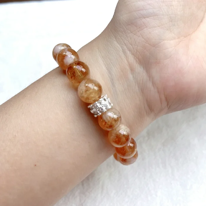 alt="yellow crystal bracelet on hand picture"