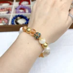 alt="yellow crystal bracelet on hand view"